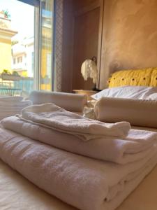 a pile of towels sitting on top of two beds at Specter Guesthouse in Nettuno