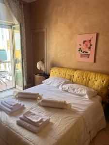 a bed with two towels on top of it at Specter Guesthouse in Nettuno