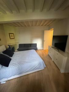 a bedroom with a large white bed and a couch at Beautiful Center Apartments - posti auto privati prenotabili in Parma