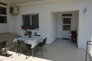 a patio with a table and chairs in a room at Apartmani Stolac in Stolac