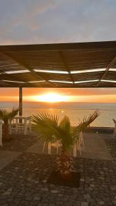 een tafel en stoelen met de zonsondergang op de achtergrond bij The View Hotel in Tongon