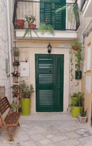 une porte verte sur un bâtiment avec des plantes en pot dans l'établissement Il Nido al Castello, à Monopoli