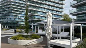 a group of white chairs and umbrellas in front of a building at Crest View 777th - Apartament & SPA in Międzyzdroje