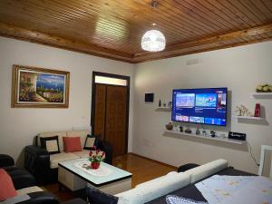 a living room with a couch and a flat screen tv at Villa Berat - Castle View & Traditional Breakfast in Berat