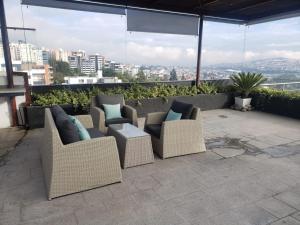 un patio con 3 sillas y una mesa en el balcón en Suite ICON, en Quito