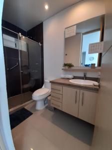 a bathroom with a toilet and a sink and a shower at Hermoso y lujoso piso 14 con Salida Directa a la playa y clubhouse increible in Santa Marta