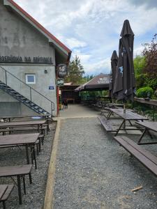 a group of picnic tables with umbrellas in front of a building at Chatičky na Hrdličce - Čím in Čím