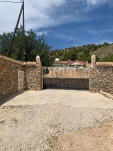 valla de piedra con puerta y pared de piedra en Casa pajarera, en Fortuna