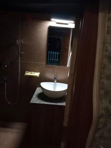 een badkamer met een wastafel en een spiegel bij YOLO RESORT in Dharān Bāzār