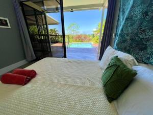 a bedroom with a large bed with a view of a pool at Macesuya Lodge in Zancudo +3 photos