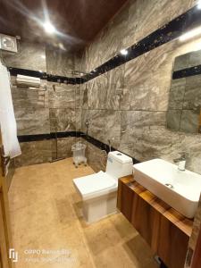 y baño con aseo blanco y lavamanos. en Auroville Home stay, en Shimla