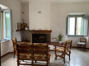 Camporgiano的住宿－Birillina al Poggio，客厅配有桌椅和壁炉