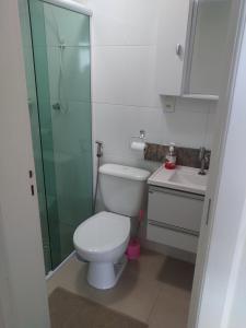a bathroom with a toilet and a glass shower at Apartamento frente mar pé na areia in Praia Grande +18 photos