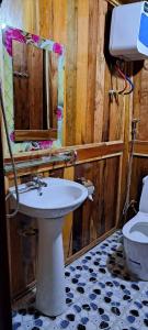 een badkamer met een wastafel, een spiegel en een toilet bij Homestay Highland Hmong in Hòa Bình