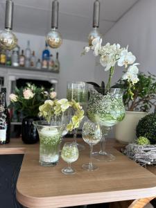 una mesa con varios vasos y un jarrón con flores en Pension Zur Alten Post en Havelberg