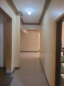 an empty hallway with a white wall and a ceiling at Picho two bedroom apartment in Malindi