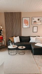 a living room with a black couch and two tables at Lille hygge in Leck