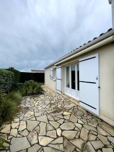 une maison avec deux portes de garage et une allée en pierre dans l'établissement L'authentique - Cosy & Calme, à La Pironnière