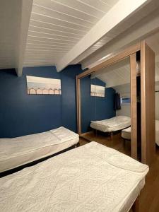 une chambre avec deux lits et un miroir dans l'établissement L'authentique - Cosy & Calme, à La Pironnière 13 autres photos