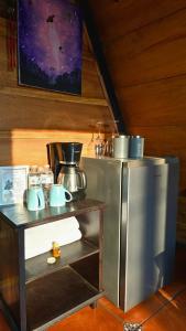 eine Küche mit einem Kühlschrank neben einem Tisch in der Unterkunft Casa Jardin De Julia in San Juan Obispo