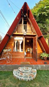 ein kleines Haus mit einem roten Dach und einer Steinterrasse in der Unterkunft Casa Jardin De Julia in San Juan Obispo