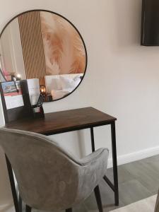 een spiegel bovenop een bureau met een stoel bij Pension Zur Alten Post in Havelberg