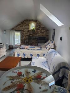 ein Schlafzimmer mit 2 Betten und einem Tisch darin in der Unterkunft Gîtes An Douar Menez in Gourin