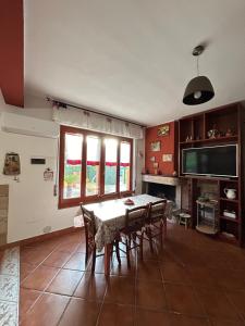 ein Esszimmer mit einem Tisch, Stühlen und einem TV in der Unterkunft Villa Azzurra Fronte Mare in Capitana