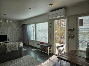 uma sala de estar com um sofá e uma mesa em Viihtyisä rivitalokolmio autopaikalla em Kangasala