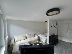 sala de estar con sofá blanco y cama en Stilvolles City-Studio en Neuss