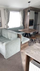 a living room with a couch and a table at T23- Pebble Bank Caravan Park in Weymouth