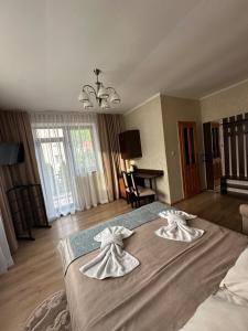 a bedroom with a large bed with two towels on it at Сонячна Перлина in Polyana