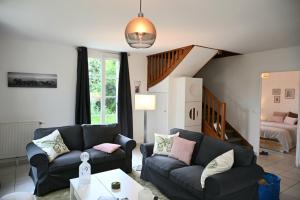 ein Wohnzimmer mit 2 Sofas und einer Treppe in der Unterkunft Disneyland Paris Modern Villa in Bailly-Romainvilliers