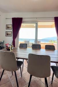 comedor con mesa grande y sillas en Villa Tre Tri en Herceg-Novi