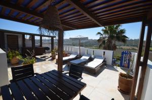 eine Terrasse mit Sofas, einem Tisch und Stühlen in der Unterkunft Les appartements de la Villa Beida in Oualidia