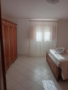 sypialnia z łóżkiem i oknem w obiekcie Casa Anna w mieście Castellammare del Golfo
