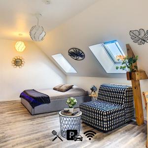 a attic bedroom with a bed and a couch at Studio'Moment Saint-Omer Centre in Saint-Omer