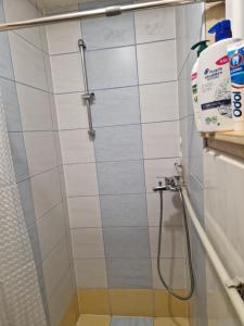um chuveiro na casa de banho com azulejos brancos em Chata na Poľane em Hriňová
