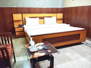 Karachi Motel Guest House في كراتشي: غرفة نوم مع سرير وطاولة مع طاولة قهوة