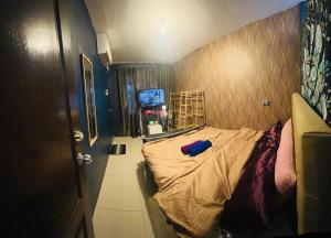 mały pokój z łóżkiem i ścianą w obiekcie Mamby Gray's Place Balcony, Karaoke ,Wifi,Netflix &Kitchen w mieście Imus