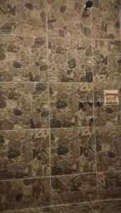 a bathroom with a stone wall with a shower at Casa Qi in Villa Giardino