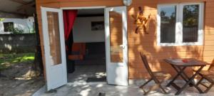 eine offene Tür eines Hauses mit einem Tisch und einem Stuhl in der Unterkunft Fred'lodge in Matoury
