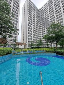 ein großer Pool vor hohen Gebäuden in der Unterkunft Grace Residences Pool View Free Wi-Fi near BGC and McKinley 2050 in Manila