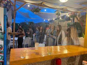 Vlora Backpackers Hostel & Bar LUNGOMARE في فلوره: مجموعة من الناس واقفين حول طاولة في مطعم
