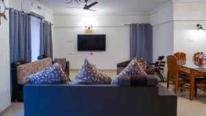 a living room with a blue couch and a table at AP's Castle Stay in Kharadi