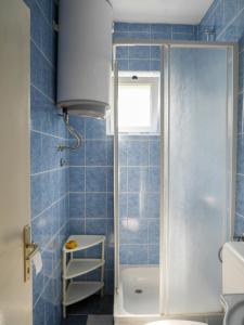 baño de azulejos azules con ducha y aseo en Studio Apartment Maršić en Zaostrog