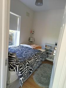 una camera da letto con un letto con un piumone bianco e nero di An Teach Beag 2 Bed Flat a Gorey