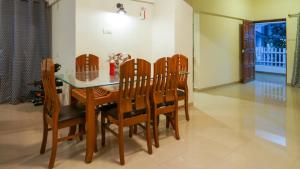 a dining room with a wooden table and chairs at AP's Castle Stay in Kharadi