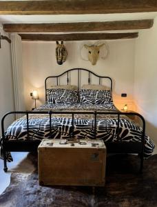1 dormitorio con 1 cama con marco de cama con estampado de cebra en Podere Relais Fabilandia en Tolè
