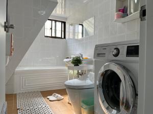 a bathroom with a washing machine and a sink at Como Green House in Busan